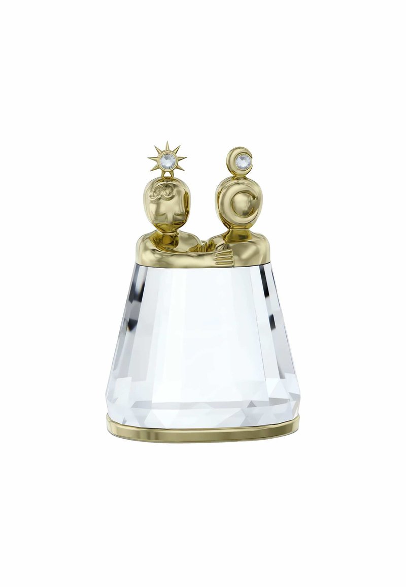 Figurina in cristallo che presenta due figure di colore oro con volti dettagliati, una decorata con un simbolo solare e l'altra con una luna, poggiante su una base sfaccettata.