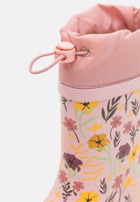 Růžová nepromokavá bota s květinovým vzorem, měkkým vrškem a elastickým stahováním, a pevným růžovým základem. Hladký povrch a flexibilní design.