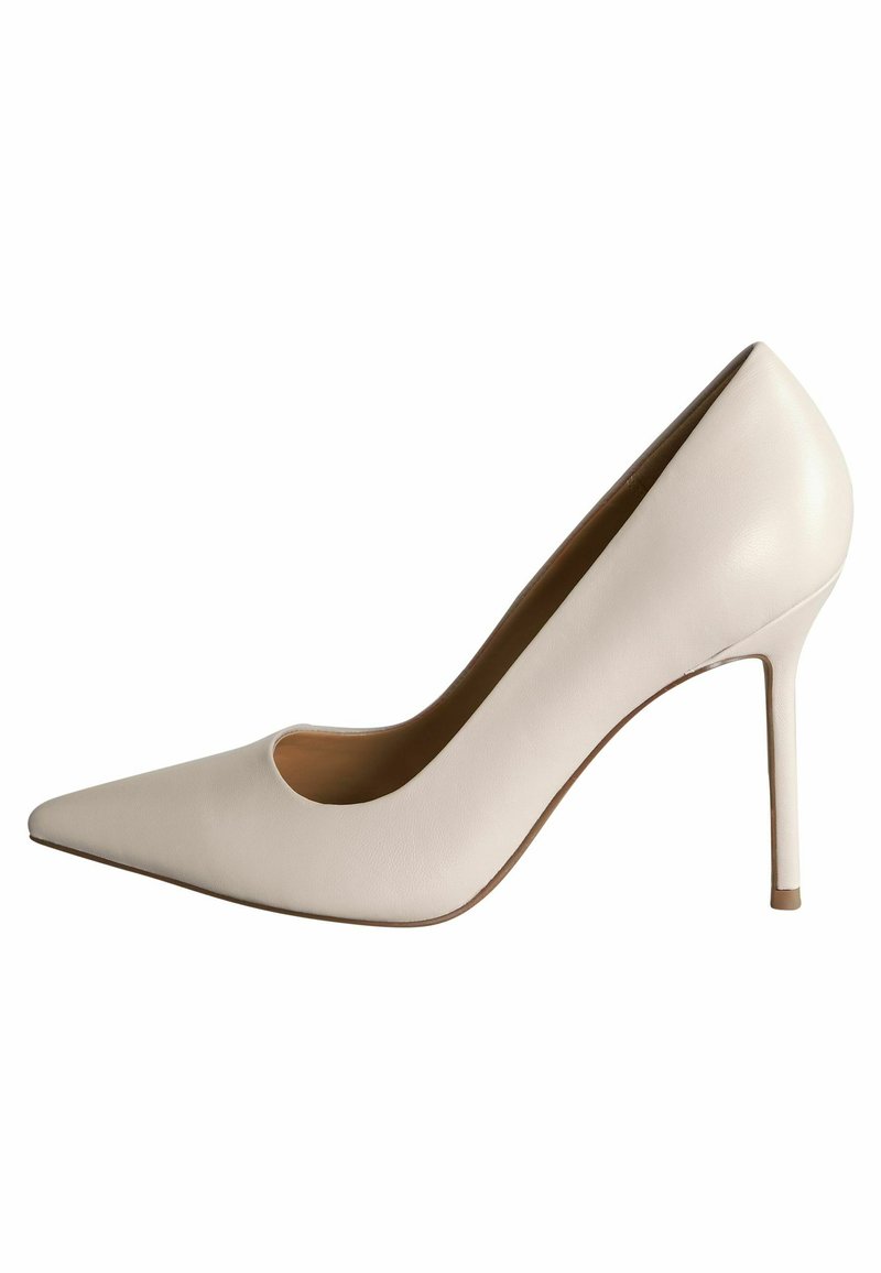 Valkoinen nahkasaapas, jossa on terävä kärki, sivuleikkaus ja ohut stiletto-korko. Sujuva pinta ja minimalismi.