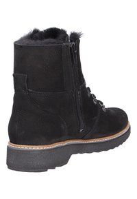 Bottines en suede noir avec un col en fourrure, fermeture éclair latérale et semelle en caoutchouc. Présente un laçage décoratif et des détails de couture.