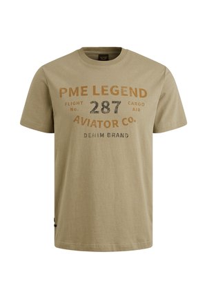 Beige Baumwoll-T-Shirt mit Rundhalsausschnitt, kurzen Ärmeln und bedrucktem Text in Braun und Schwarz. Das Design enthält Marken- und Fluginformationen.