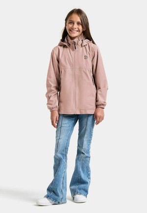 Jasnoróżowa wodoodporna kurtka z kapturem, przednim zamkiem błyskawicznym i czarnym logo. Nosi się ją z dżinsami z rozszerzanymi nogawkami i białymi butami, z widocznymi szczegółami przeszyć.