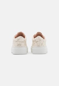 Valkoiset lenkkarit, joissa on teksturoitu, kuviollinen päällinen ja beigenvärisiä yksityiskohtia. Paksu pohja on valkoinen, ja siinä on kumimainen, teksturoitu pinta.