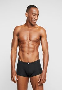 Black boxer briefs made of soft fabric, featuring a snug fit and a comfortable waistband with a logo. Appears smooth with no visible patterns.