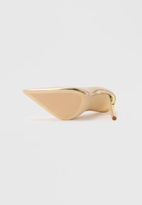 Single gold high heel shoe shown from the sole, featuring a pointed toe and thin stiletto heel on a white background.