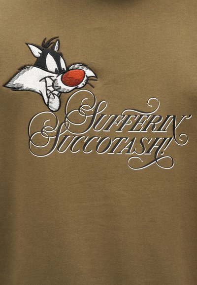 Πρόσωπο του καρτούν χαρακτήρα Σίλβεστερ με το κείμενο «Sufferin' Succotash!» σε διακοσμητική λευκή γραμματοσειρά σε καφετί υφασμάτινο φόντο.