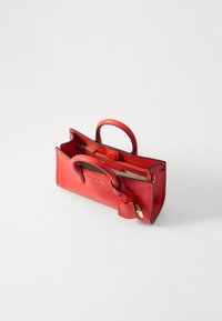 Borsa a tracolla in pelle rossa con due manici tondi, tasca con zip e dettaglio in nero a contrasto. Presenta un logo dorato sul davanti.