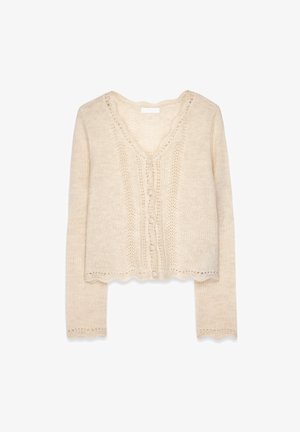Beige verkürzter Cardigan mit langen Ärmeln, V-Ausschnitt und Knopfverschluss. Mit Spitzenapplikationen und gewellten Kanten. Weiche Textur.