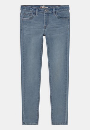 Jean skinny bleu clair avec bouton à l'avant, fermeture éclair, deux poches avant et deux poches arrière, posé à plat sur un fond blanc.