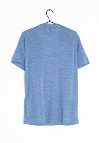 Blå kortærmet t-shirt hængende på en sort krog. Lavet af tekstureret stof med en let meleret mønster og design med rund hals.