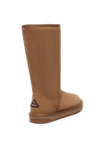 Hellbraune Stiefel bis zur Mitte der Waden aus weichem, strukturiertem Stoff mit runder Zehenpartie, flacher Gummisohle und einem Logo auf der Rückseite.