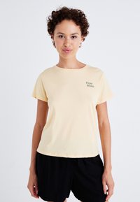 Žluté bavlněné tričko s kulatým výstřihem, krátkými rukávy a malým zeleným logem "Pepe Jeans" na levé části hrudi.