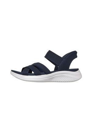 Sandalia azul marino con puntera abierta, tres tiras delanteras y una tira en el tobillo, con suela blanca texturizada y flexible.