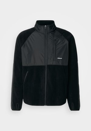 Black fleece jacket with a zippered front, raglan sleeves, and a textured panel at the chest. Features side pockets and a high collar.