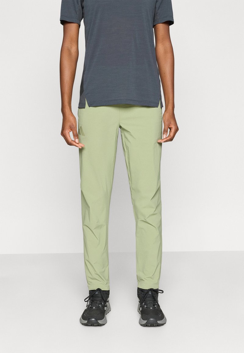 Φωτεινό πράσινο, στενά εφαρμοστά παντελόνια κατασκευασμένα από λείο, ελαφρύ ύφασμα. Διαθέτουν πλαϊνές τσέπες και ελαφρώς στενό πόδι. Συνδυασμένα με σκούρο γκρι τοπ.