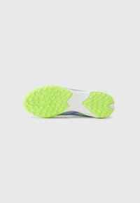 Chaussures avec une semelle extérieure en caoutchouc texturé et vert vif, dotées d'une semelle intermédiaire blanche et d'un dessus coloré avec des motifs.