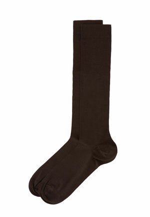 Braune kniehohe Socken aus einem glatten, dehnbaren Stoff. Sie verfügen über einen gerippten Bund und ein nahtloses Zehen-Design für zusätzlichen Komfort.