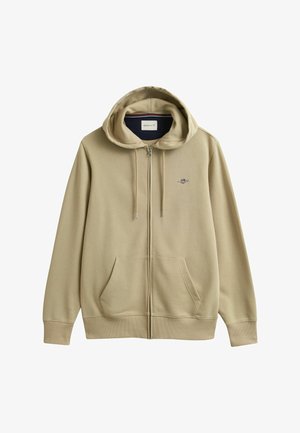 Sweat à capuche beige zippé avec poches avant, capuche avec cordon de serrage, poignets côtelés et petit logo brodé sur le côté gauche de la poitrine.