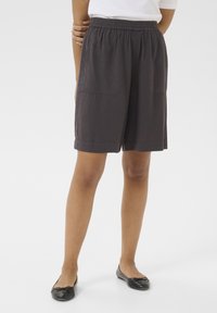 Pantaloni corti in lino grigi con cintura elastica, due tasche frontali e vestibilità ampia, abbinati a ballerine nere.