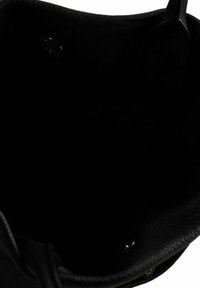 Interieur van een zwarte leren totebag met een gestructureerd oppervlak, voorzien van een enkele drukknoopsluiting en zonder zichtbare vakken of compartimenten.