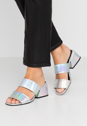 Holographic block-heeled sandals with two wide bands, open toe, and a glossy finish. The heel is squared and has a black base.