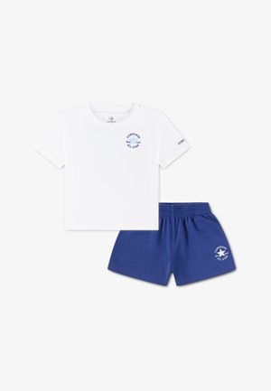 Maglietta bianca in cotone con logo blu "Converse All Star". Abbinata a pantaloncini corti blu in cotone con logo coordinato sul lato.