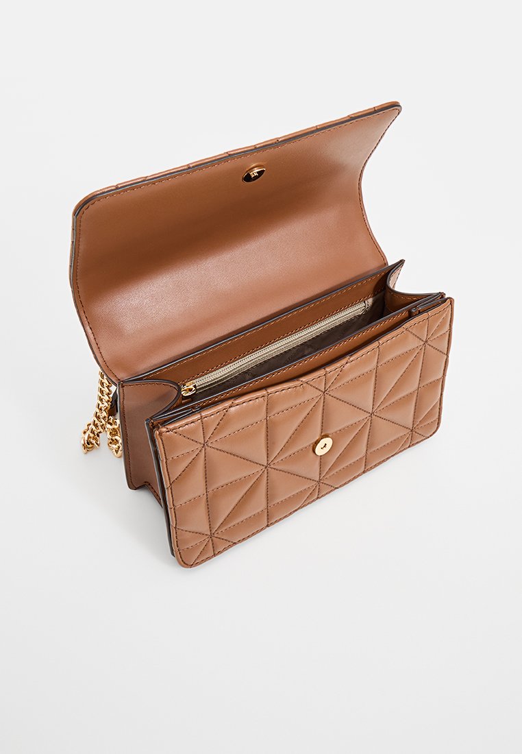 Borsa a tracolla in pelle trapuntata color sabbia con chiusura a scatto dorata e tracolla a catena. L'interno presenta diversi scomparti e una tasca con zip.