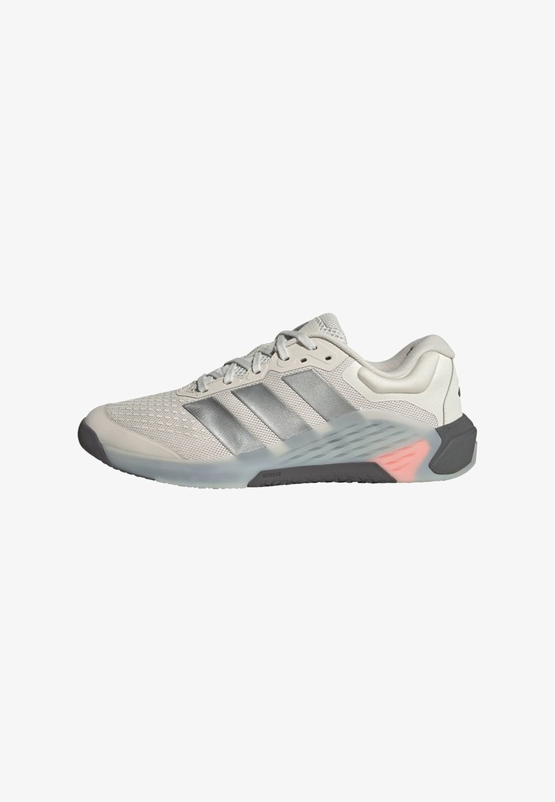 Lys grå atletiksko med en åndbar mesh-overdel, sølvstriber, en polstret krave og en tekstureret gummisål med pink detaljer.