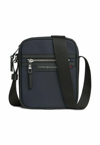 Borsa a tracolla compatta in nylon blu navy con cerniera nera, cinturino regolabile e branding frontale. Presenta una forma rettangolare elegante.