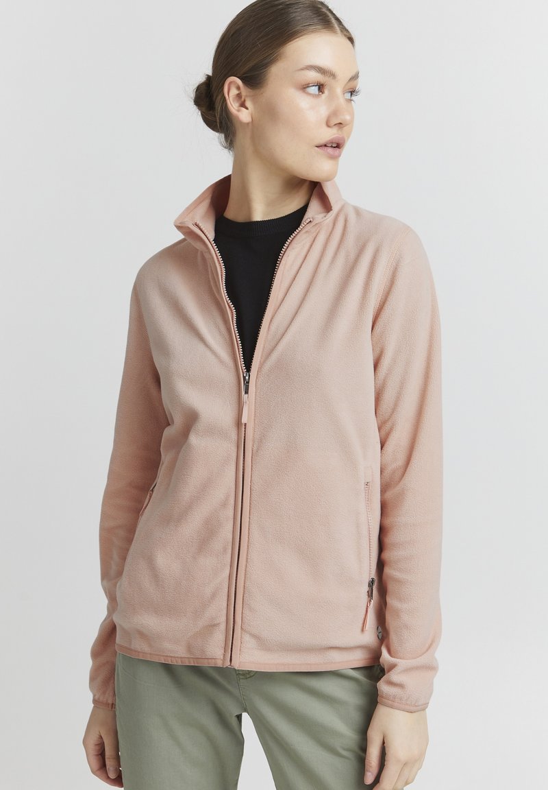 Lichtroze fleece jack met een hoge kraag, volledige ritssluiting en zijzakken. Beschikt over een zachte textuur en lange mouwen.