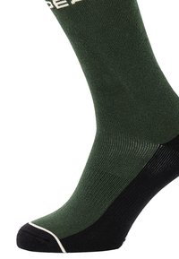 Zielona skarpeta z czarną wkładką, z prążkowaną teksturą i kontrastującymi białymi paskami przy krawędzi. Wzmocniona strefa palców.