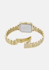 Reloj de pulsera Armani Exchange en tono dorado con cara rectangular, pulsera de eslabones metálicos y cierre abierto, mostrado desde atrás.
