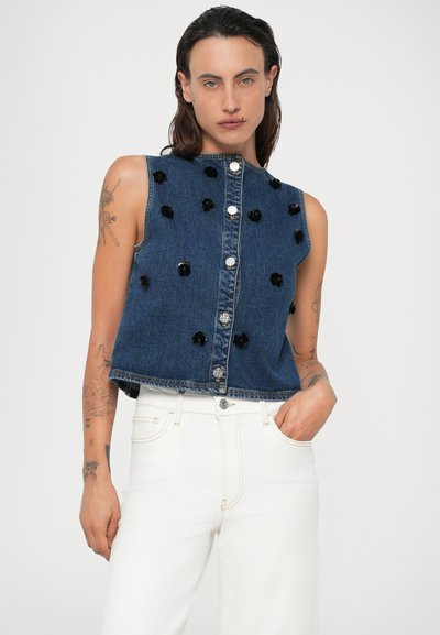 Jeans brez rokavov s temno modrim odtenkom, okrašenim s črnimi cvetličnimi aplikacijami in srebrnimi gumbi spredaj.