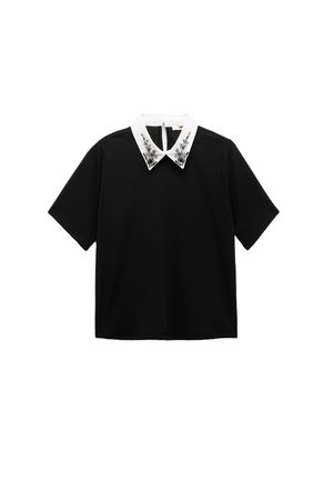 Black short-sleeve top with a white collar adorned with silver floral embellishments, featuring a back zipper closure.
