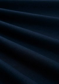 Ciemnogranatowa tkanina o gładkiej fakturze, z delikatnymi fałdami i jednolitym wzorem, tworząca efekt głębi i trójwymiarowości.