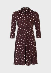 Brązowa sukienka do kolan z zapięciem na guziki z przodu i kołnierzykiem. Posiada białe kropki, długie rękawy i rozkloszowany fason spódnicy.