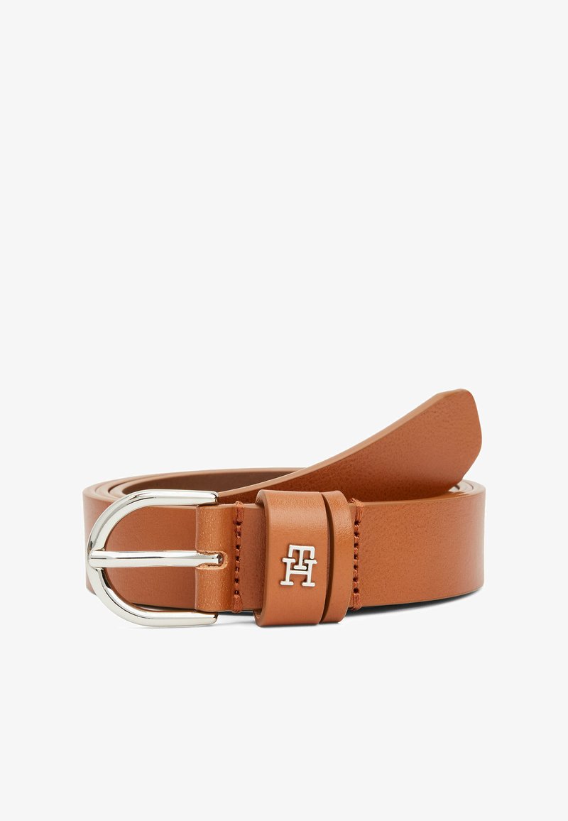 Ceinture en cuir beige avec une boucle en métal argenté, des détails de couture sur les bords et un accent logo sur le passant. Texture lisse dans son ensemble.