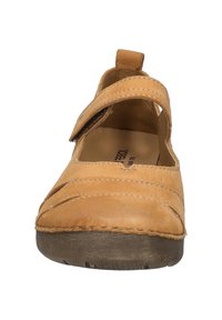 Zapato de cuero marrón claro con puntera redonda, tira ancha en el empeine y costuras en contraste. Suela de goma con acabado texturizado.