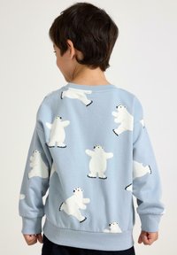 Hellblauer Sweatshirt mit verspielten weißen Eisbär-Designs. Gerippte Bündchen und Saum, weicher Stoff mit glatter Textur.