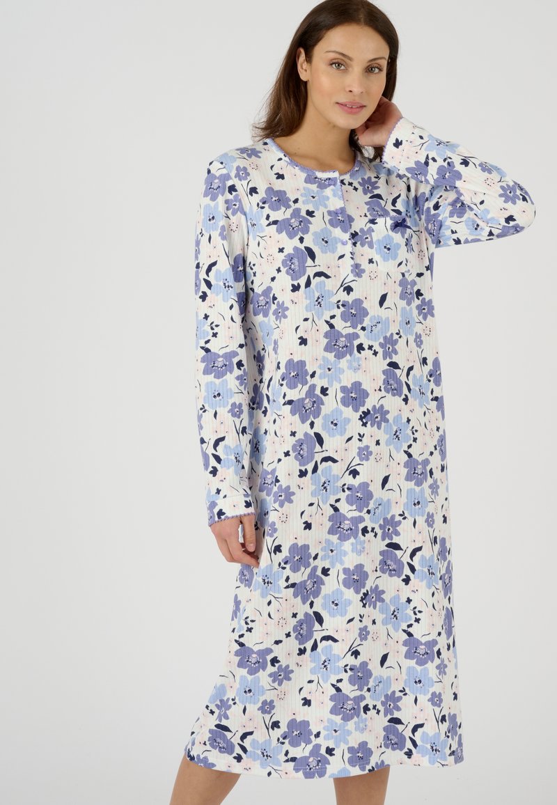 Camisa de noche floral de mangas largas, con un patrón de flores lavanda y azules sobre un fondo claro, hecha de una tela suave y con un escote redondo.