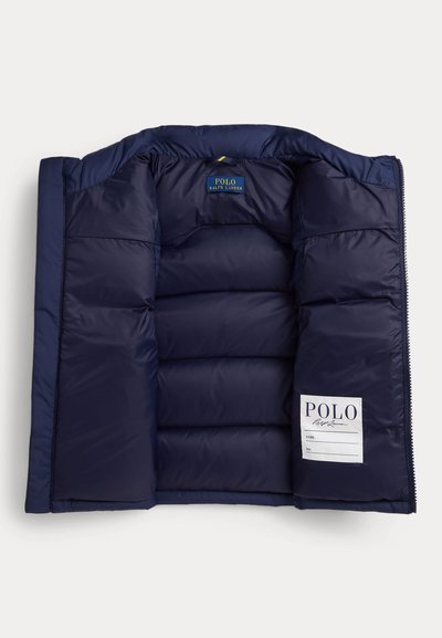 Laivastonsininen toppatakki avattuna ja litistettynä, paljastaen sisäiset tikatut paneelit ja Polo Ralph Lauren -merkit ommeltuna sisäpuolelle.