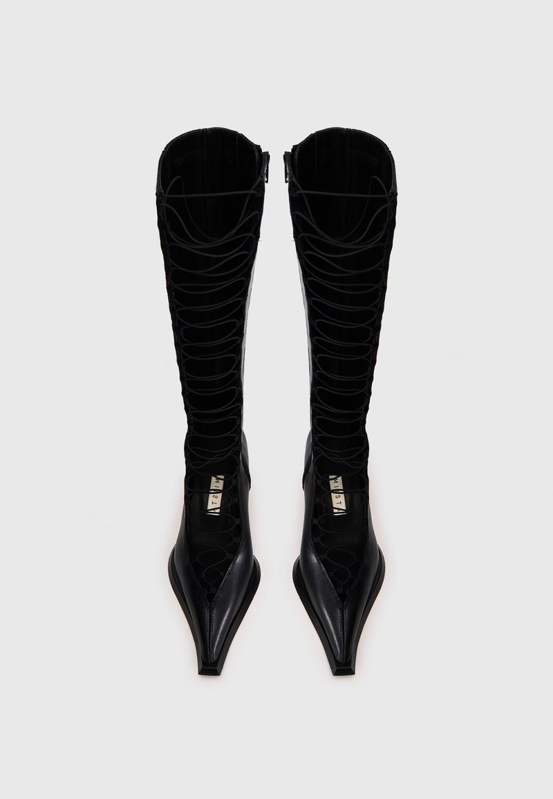 Schwarze kniehohe Stiefel mit spitzer Spitze, ausgestattet mit einem Schnürdesign und strukturierten Einsätzen. Hergestellt aus glattem Leder mit glänzendem Finish.