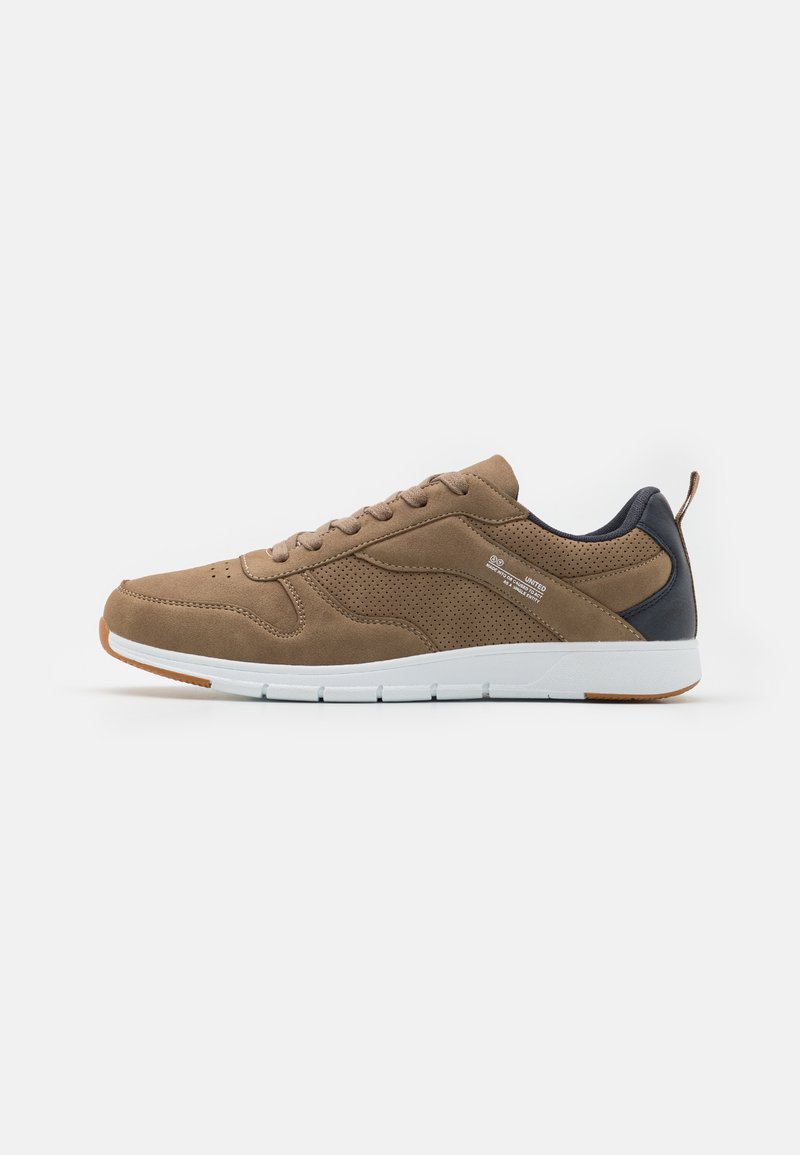 Brown suede sneaker with mesh sides, white sole, and dark brown heel accent. Features six eyelets and perforated detailing for breathability.
