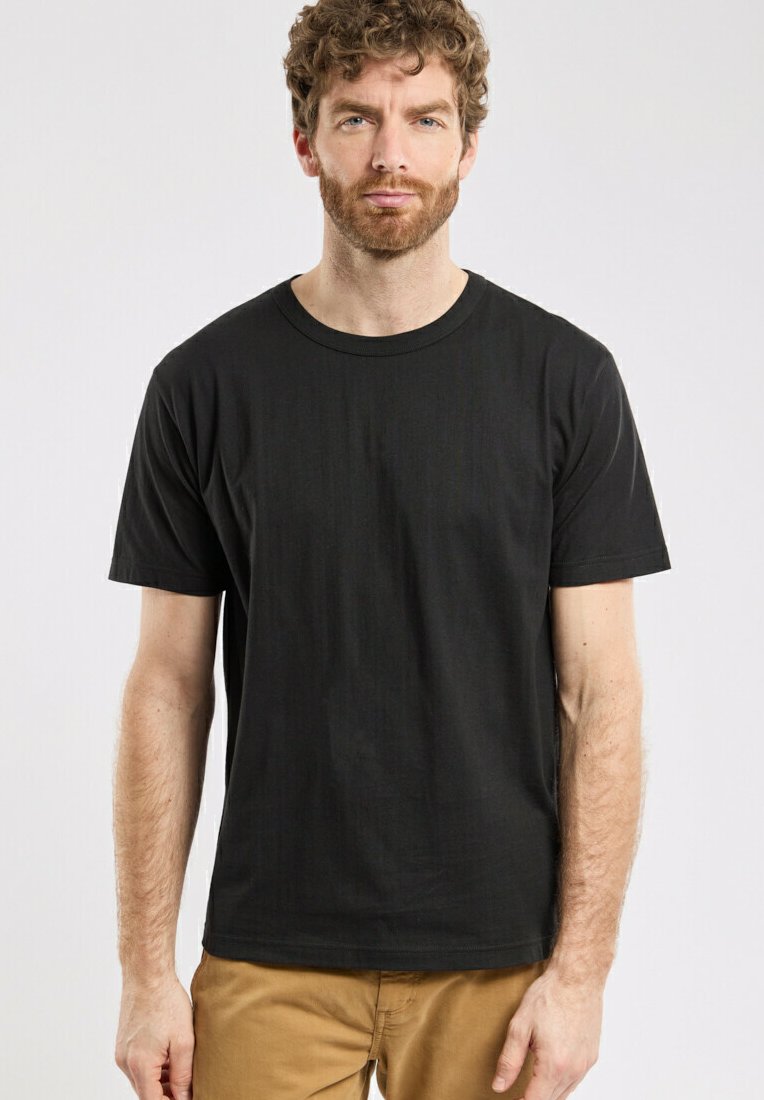 T-shirt en coton noir avec des manches courtes, un col rond et une texture lisse. Design simple, sans graphiques ni logos.