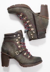 Par de botas de cuero de tobillo verde oscuro con tacones gruesos, cordones burdeos, cremalleras laterales, ojales de metal y lengüetas decorativas de tela.