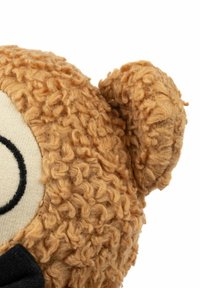 Cap de ursuleț maro cu textură crețată, față din material crem cu accente negre și o papion negru. Detaliu ureche rotunjită vizibil.