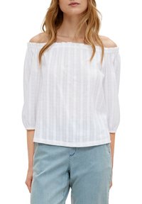 Blusa bianca scollata sulle spalle, con scollatura arricciata, maniche a sbuffo tre quarti e sottili righe verticali. Tessuto leggero.