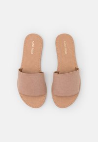 Des sandales à enfiler beige clair avec une large sangle en tissu et une semelle en fausse cuir lisse avec des accents cousus. Design minimaliste sans texture.