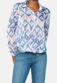 Camicia a bottoni in tessuto trasparente con un motivo geometrico blu, rosa e bianco. Maniche lunghe con colletto classico e una leggera texture.