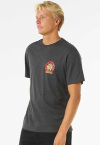 Dark gray cotton t-shirt with short sleeves, featuring a circular red and yellow logo on the left chest depicting a dog and text.